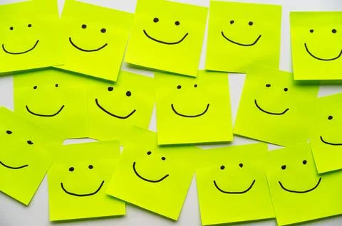 Sheets of paper with smiley faces drawn on them. Stock Photos