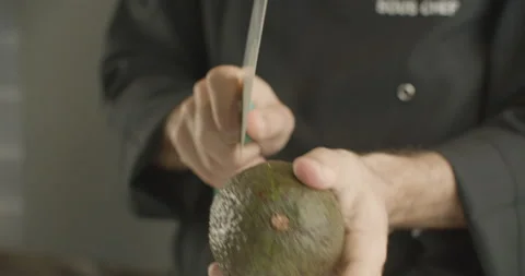 Сhef cuts the avocado in half with knife. 4K slow motion video Stock Footage 103580968