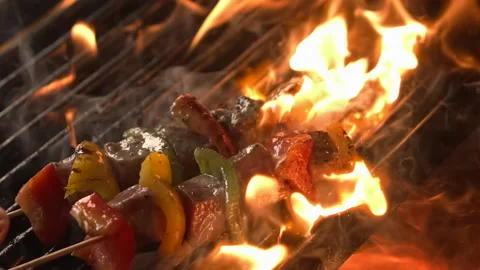 Сhef's hand puts fresh meat skewers on the open fire grill Stock Footage 157842929