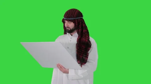 Sheikh looking at blueprint and at the object on a Green Screen, Chroma Key. Stock-Footage 138541587