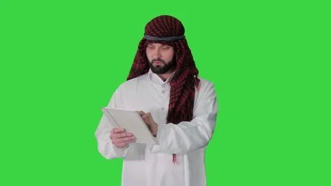 Sheikh presenting information or product using digital tablet on a Green Screen Stock Footage 136672331