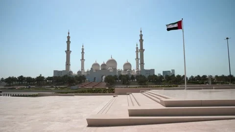 Sheikh Zayed Grand Mosque in Abu Dhabi with large UAE flag in United Arab Emi Stock Footage 154138959