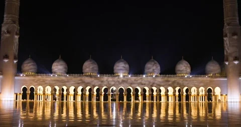 Sheikh Zayed Grand Mosque's domes and arches mirrored on marble floor at nigh Stock Footage 273589268