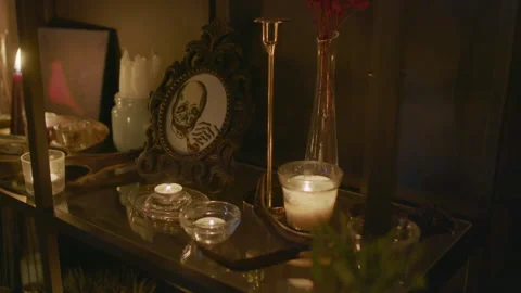 Shelf with Burning Candles, Candlesticks and Posters Stock Footage 247641681