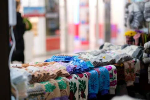 Shelf with hand crafted wool socks with patterns in store Foto stock