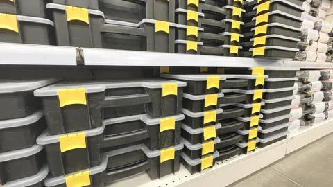 A shelf of plastic containers with yellow handles. The containers are stacked on Stock Photos