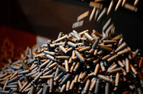 Shell casings fall down in ammunition production workshop Stock Photos