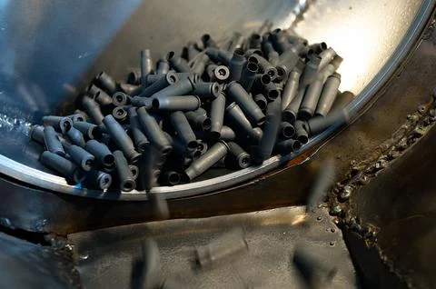 Shell casings fall down in ammunition production workshop Stock Photos