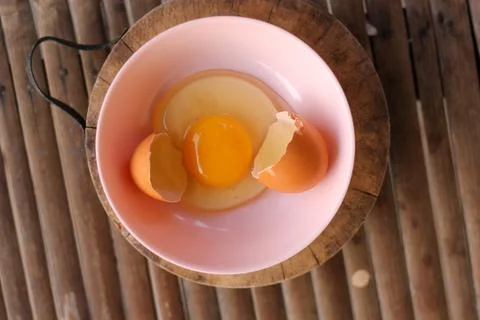 Shell with egg and open Eggs in a pink bowl Placed on the butcher on Bamboo b Stock Photos
