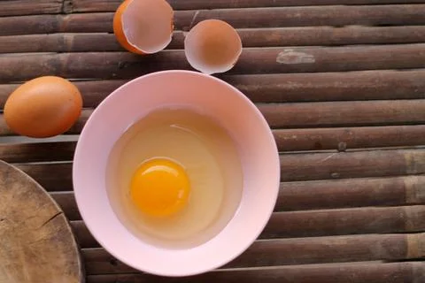 Shell with egg and open Eggs in a pink bowl Placed near to the butcher on Bam Stock Photos