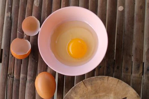 Shell with egg and open Eggs in a pink bowl Placed near to the butcher on Bam Stock Photos