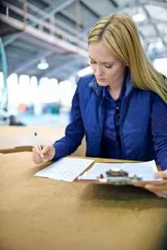Shell ensure your shipment is there on time. a woman checking the stock in a Stock Photos