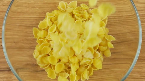 Shell-shaped pasta is poured into a glass transparent bowl. 動画素材 304381505