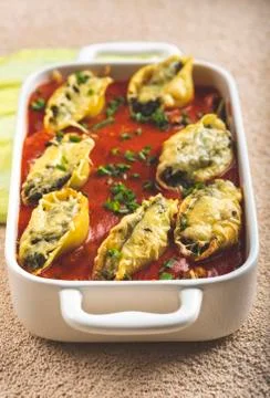 Shell-shaped pasta stuffed with spinach and cheese Stock Photos