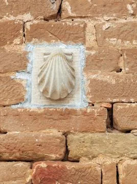 Shell symbol mounted on brick wall along the Camino de Santiago pilgrimage .. Stock Photos