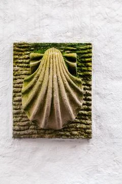 A shell symbol, representing pilgrimage, is affixed to a rustic brick wall al Stock Photos