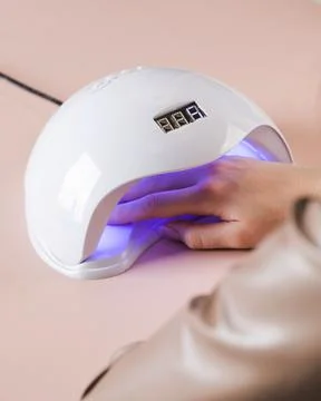 Shellac coated manicure. Drying process of gel polish in an ultraviolet lamp. Foto stock