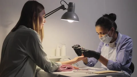Shellac coating. nail service master in beauty salon makes manicurist to client Stock Footage 225325026