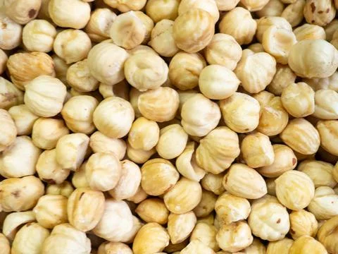 Shelled hazelnuts. Background of nuts without shells. Snack on the table. Squ Stock Photos