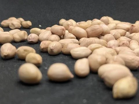Shelled Peanuts Falling on Dark Surface – Food Macro Shot Фото