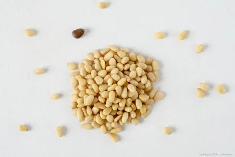 Shelled pine nuts lined hill, white background Stock Photos