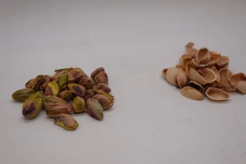 Shelled pistachios and empty shells on white background Stock Photos