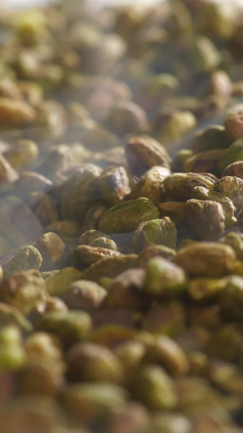 Shelled Pistachios Roasting on Flat Tray with Steam Rising Macro Close Up Stock Footage 334266702
