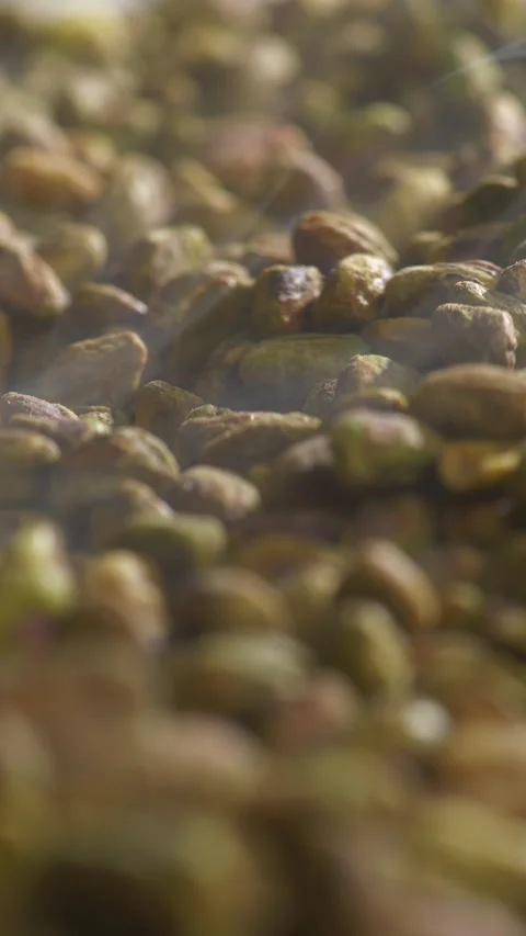 Shelled Pistachios Roasting on Tray Camera Tilting Up Macro Steam Rising Close Stock Footage 334267874