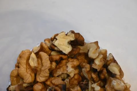 Shelled walnut pieces on a white surface Stock Photos