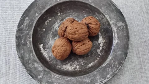 Shelled walnuts in a bowl rotating Stock Footage 248750772