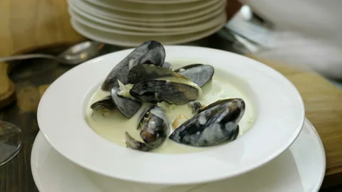 Shellfish seafood. Close-up of cooked mussels in cream sauce on white plate. 4K Stock Footage 91748794