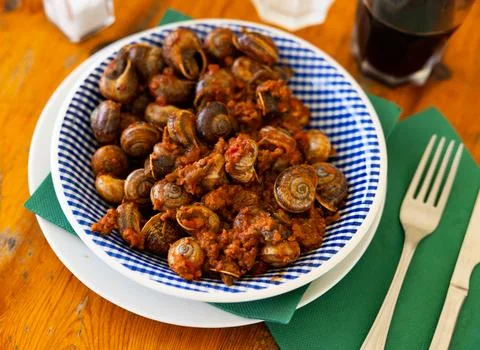 Shellfish snail cooked with minced meat and tomato dressing Stock Photos