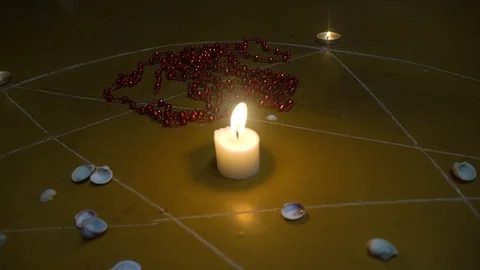 Shells and stones, white candles burn in pentagram on wooden floor. Video stock 121959165