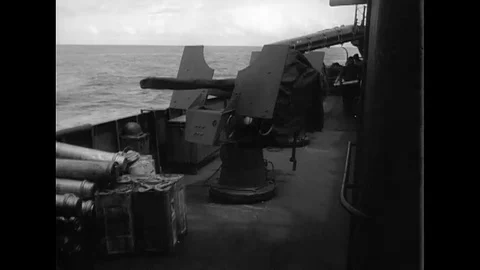 Shells are loaded and crewman position an antiaircraft gun aboard a warship Stock Footage 107166655
