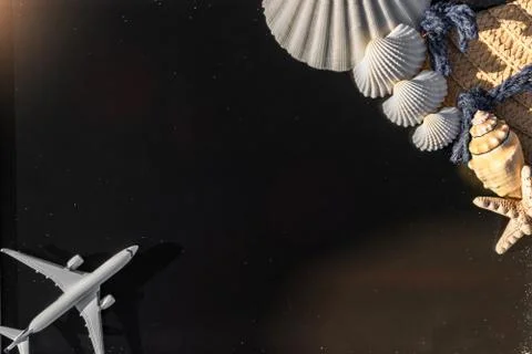 Shells background. Globe, seashell, airplane and starfish near black desk on  Stock Photos