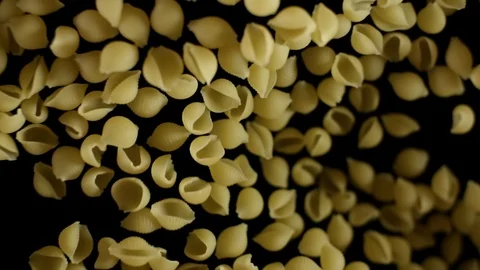Shells pasta flies after being exploded. Pile of italian pasta macaroni bouncing 스톡 동영상 105855298