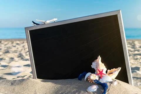 Shells pattern. Globe, seashell, airplane and starfish near black desk on sea Stock Photos