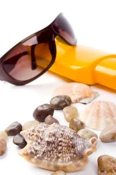 Shells, sunglasses and lotion Stock Photos