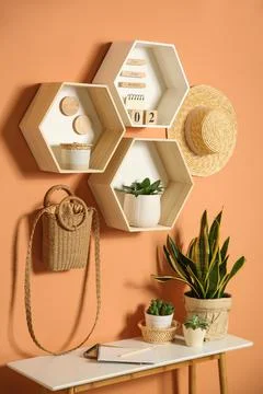 Shelves and table with decorative elements on color wall. Interior design Stock Photos