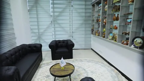 Shelves, black armchairs and sofas. White room with blinds Stock Footage 162117063