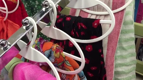 Shelves with clothes with bright multi-colored scarves in a shopping center Stock Footage 120695731