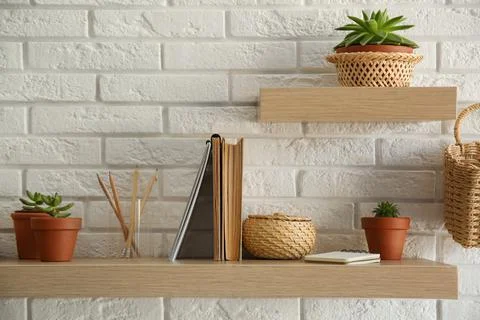 Shelves with decorative elements on white brick wall. Interior design Stock Photos