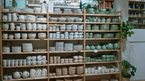 Shelves filled with various ceramic kitchenware items in an indoor shop set.. Stock Footage 312866953