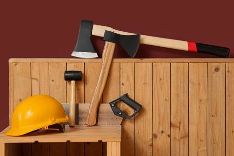 Shelving unit with tool boxes, hardhat and axes in carpenter's workshop, clos Stock Photos