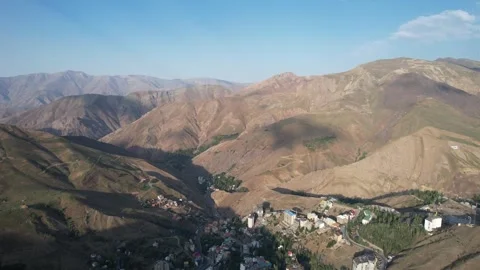 Shem mountain ridges roll under a blue sky, aerial highland folds with Stock Footage 343804802