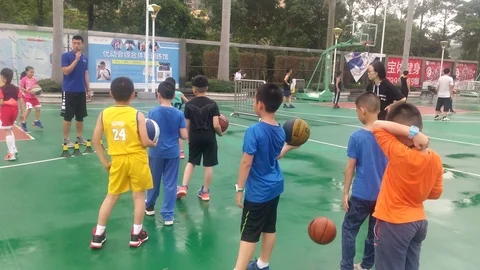 Shenzhen, China: elementary school students practice playing basketball Stock Footage 106735557