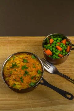 Shepherds or cottage pie in serving dish with parsley, portrait. Stock Photos