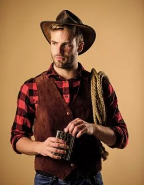 Sheriff concept. Brutal cowboy drinking alcohol. Man handsome cowboy beige Stock Photos