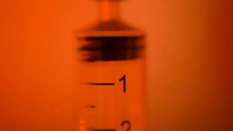 Sheritz is filled with liquid on a red background. macro. Stock Footage 104803948