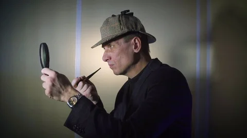 Sherlock holmes in studio detective at work with magnifying glass and pipe Stock Footage 73106633